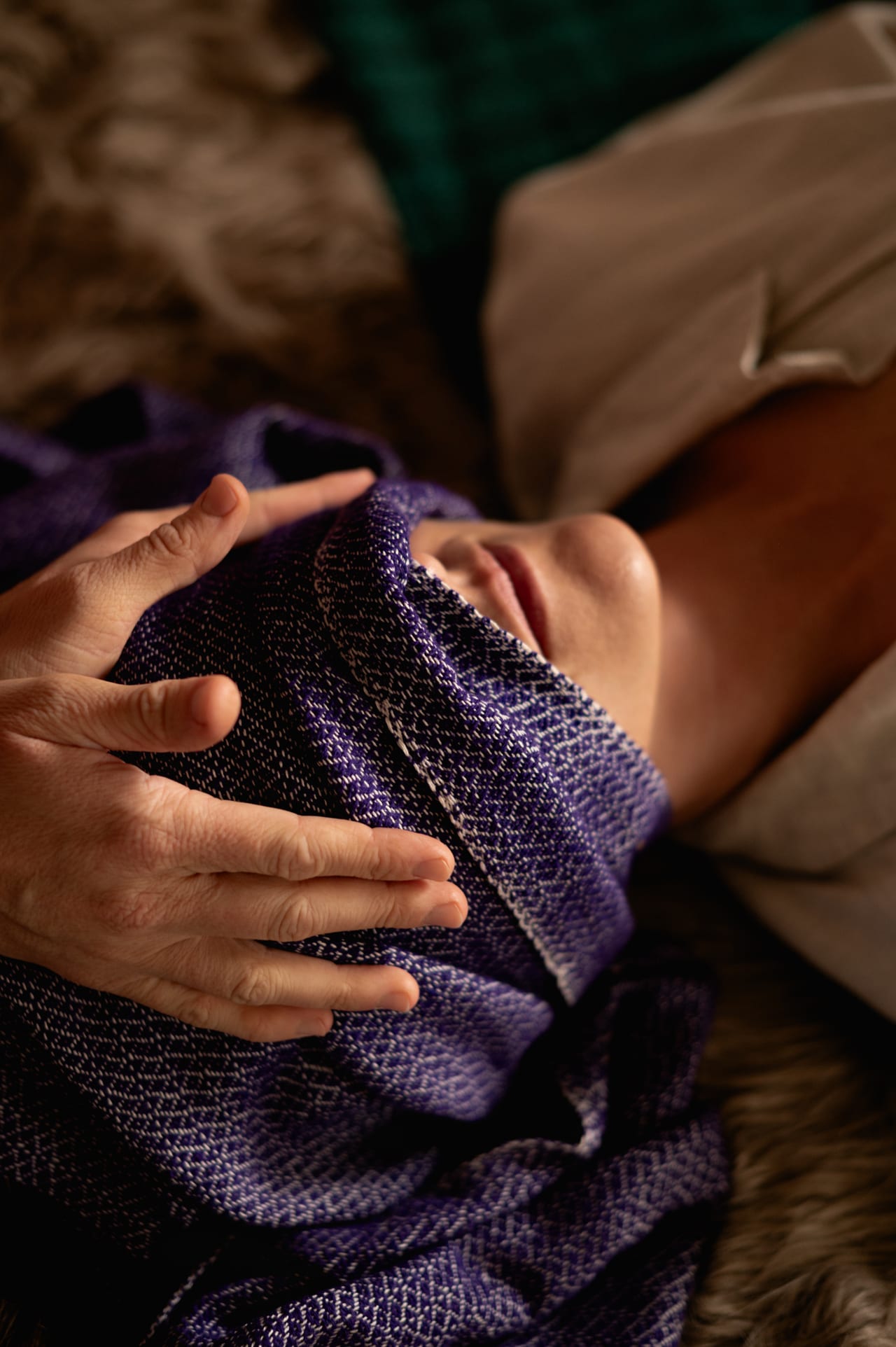 Rebozo massage setup with folded shawls and a treatment table
